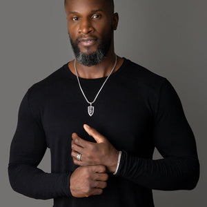 a man wears a shining shield shaped silver lion pendant and matching silver bracelet