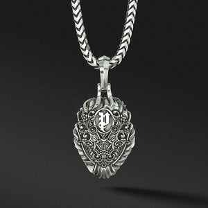 The back of a silver lion pendant features a royal pattern and the Proclamation Jewelry logo
