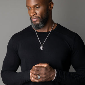 a man wears a shining silver lion pendant and matching silver bracelet