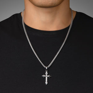 a man in a black shirt wears a sterling silver cross pendant