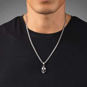 a man in a black shirt wearing a silver necklace and small skull pendant