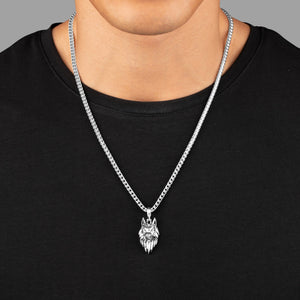 a man in a black shirt wears a sculpted silver wolf pendant