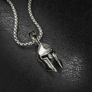 a silver Spartan helmet necklace laying on black leather