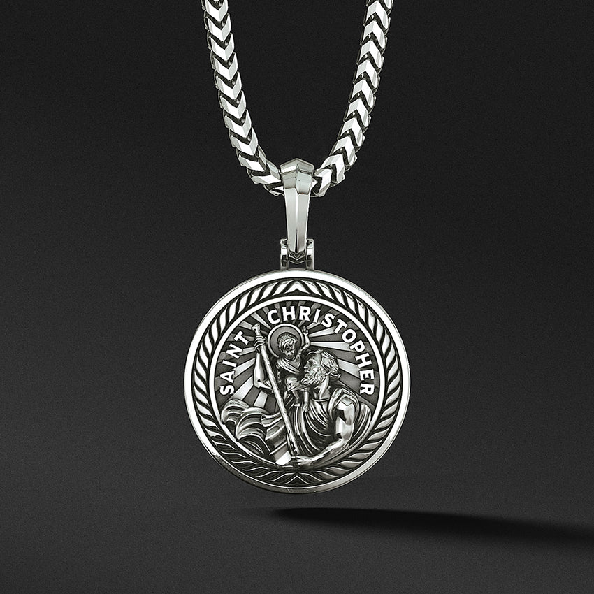 a round and polished silver Saint Christopher pendant with the sculpted saint carrying baby Jesus
