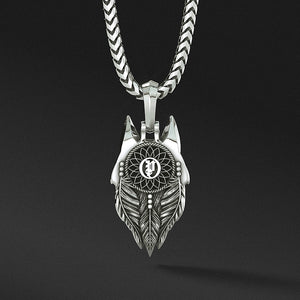 The back of a silver wolf pendant features a dreamcatcher