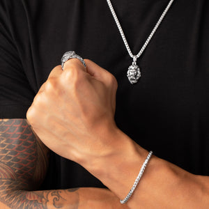 a man wears a silver dragon ring and makes a fist
